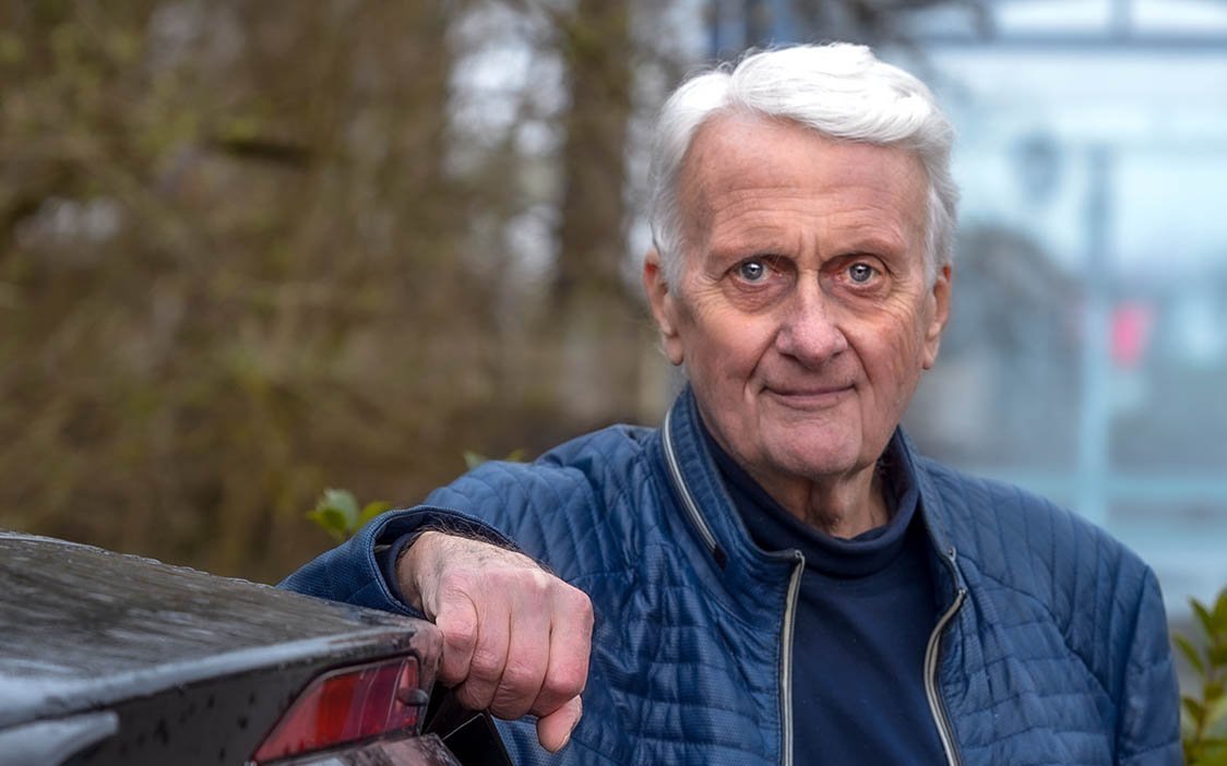 Ernst Roeckl lehnt an seinem Auto und schaut in die Kamera