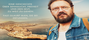 Bärtiger Mann mit Brille blickt geradeaus hinter ihm die Umrisse einer Stadt am Meer Bärtiger Mann mit Brille blickt geradeaus hinter ihm die Umrisse einer Stadt am Meer