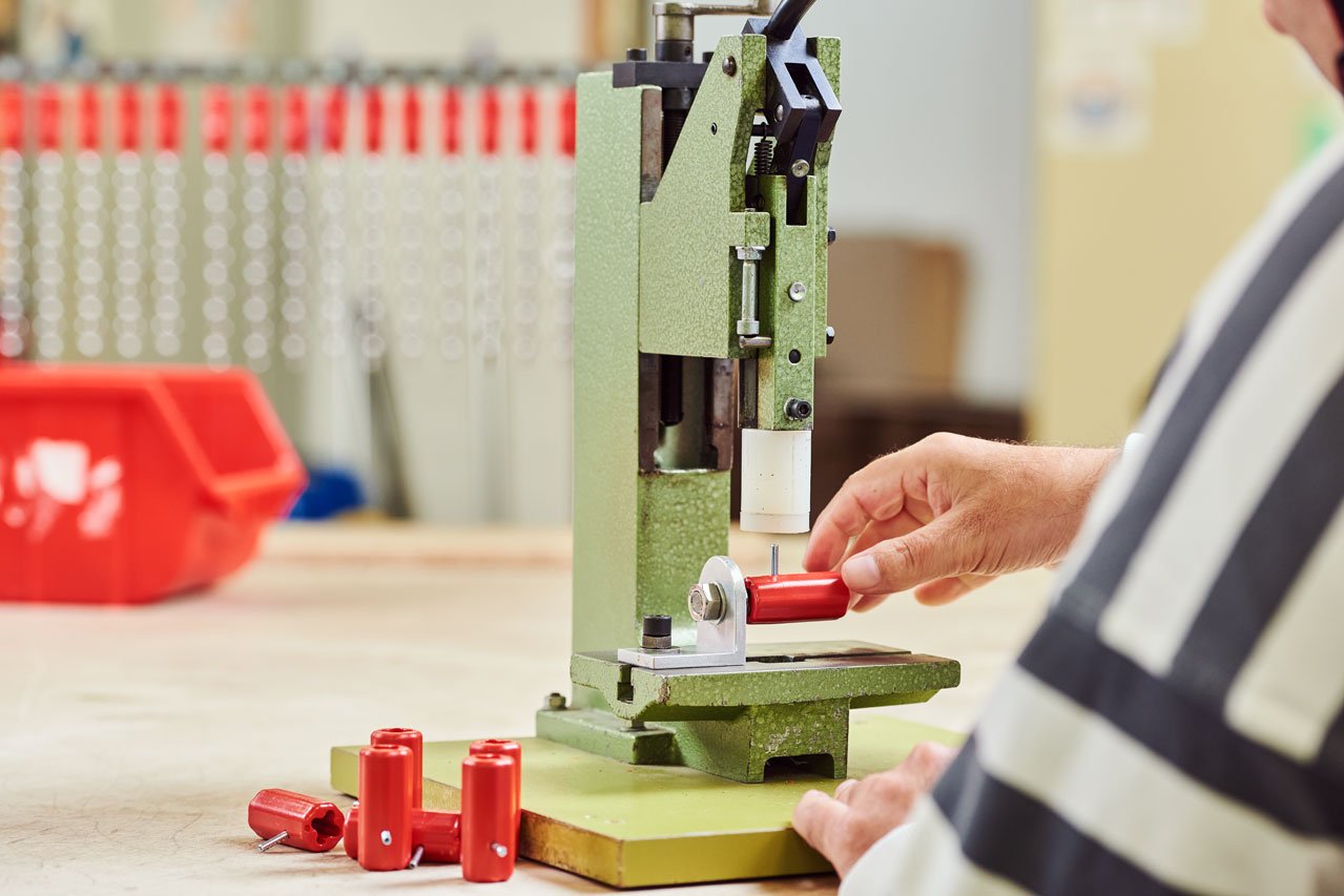 Montage und Verpackung Ein*e Klient*in arbeitet an einem Gerät