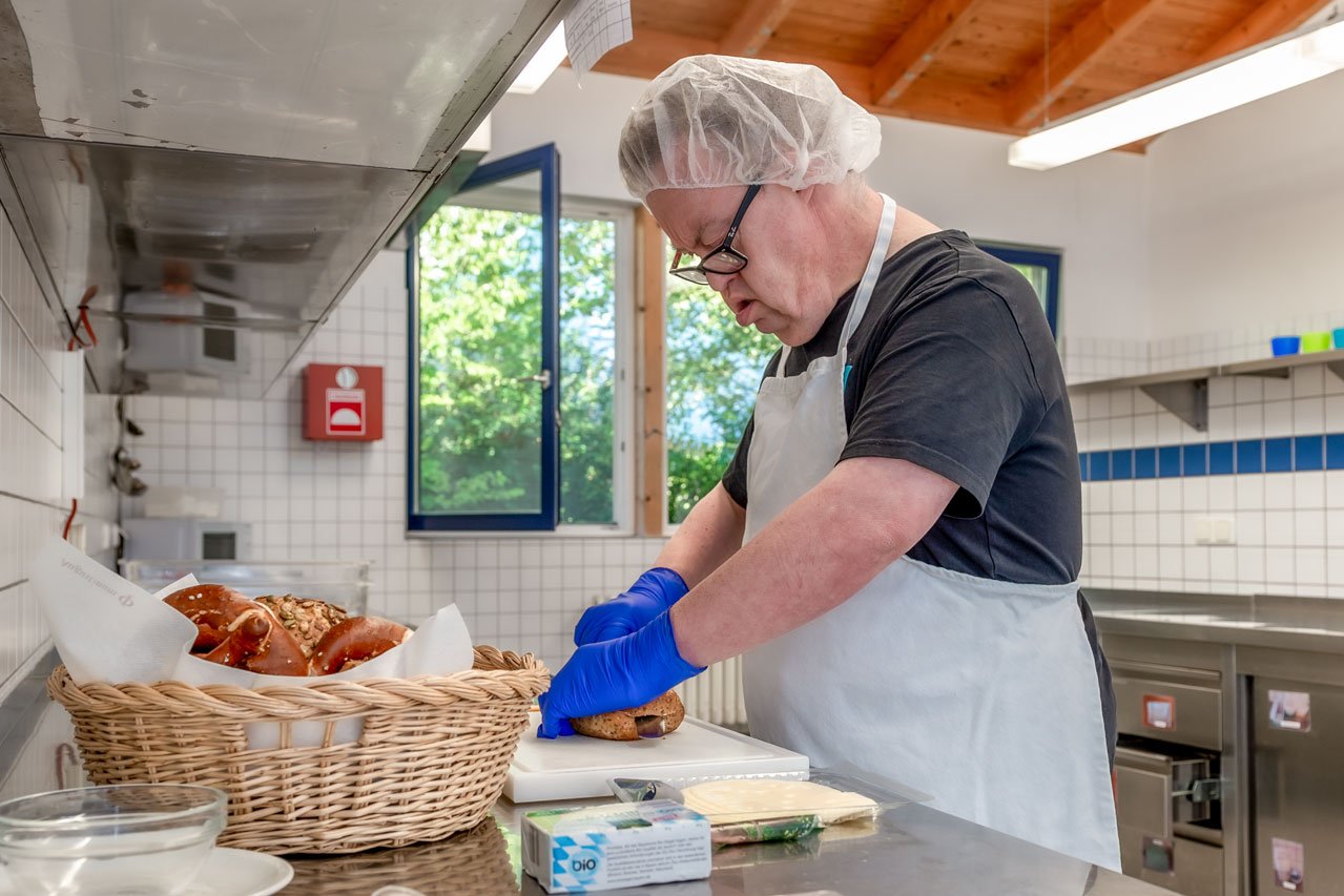 Backwarenzubereitung Ein Klient der Augustinum Gärtnerei Hollern belegt Backware