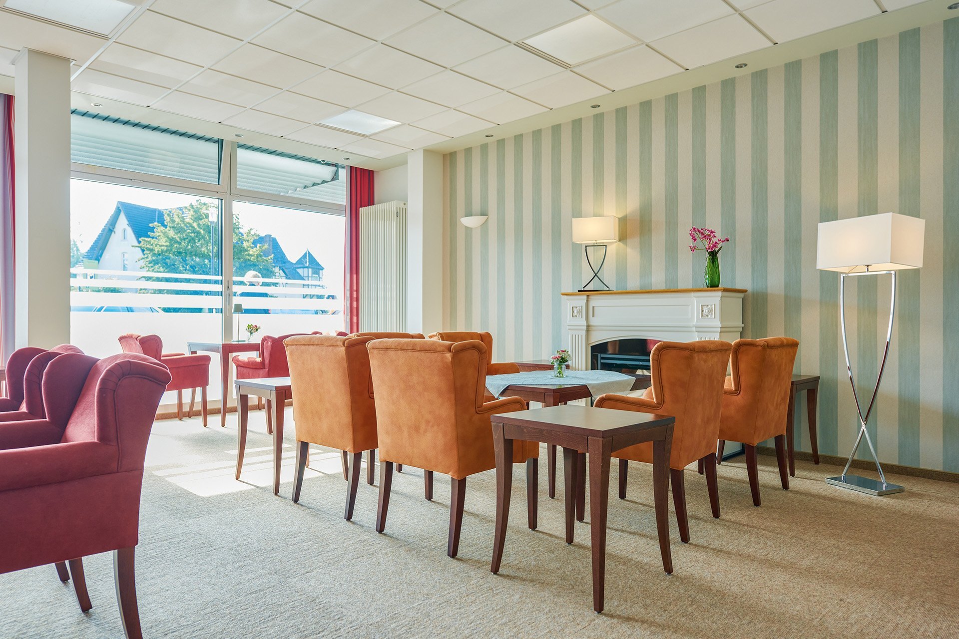 Augustinum Seniorenresidenz Kassel Salon Tische umgeben von bequemen Sitzmöglichkeiten stehen in einem hellen Raum