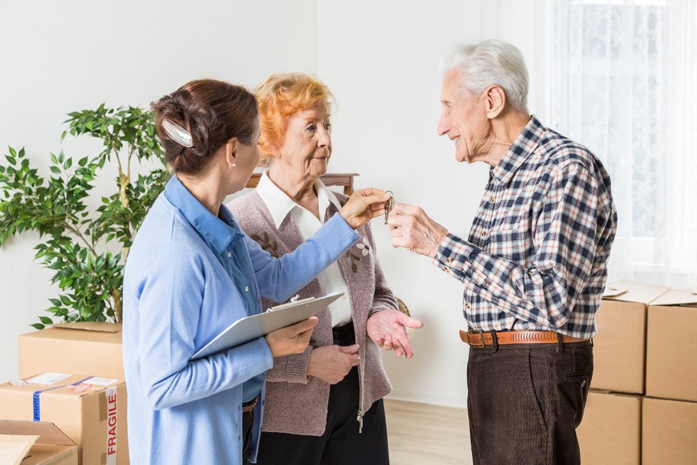Die Augustinum Einzugsbegleitung hilft Ihnen beim Einzug Übergabe der Wohnungsschlüssel an ein älteres Paar