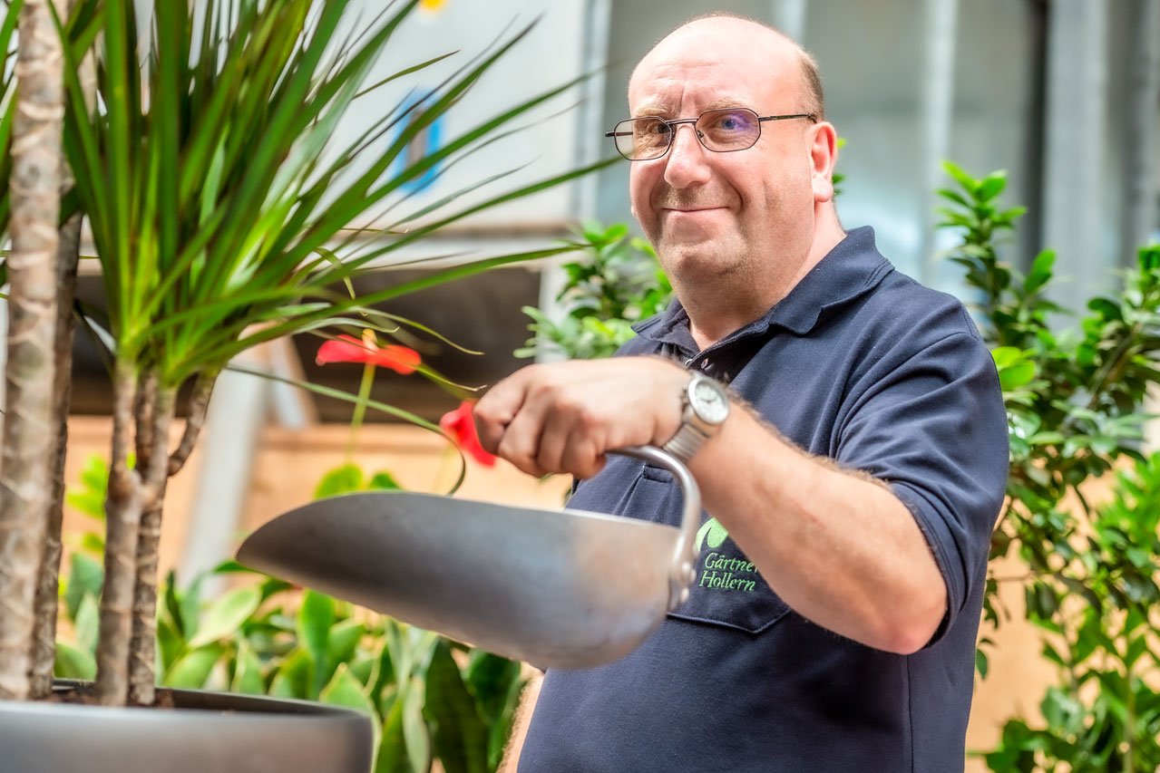 Nachfüllen von Blähton Ein Klient der Augustinum Gärtnerei Hollern füllt Blähton nach