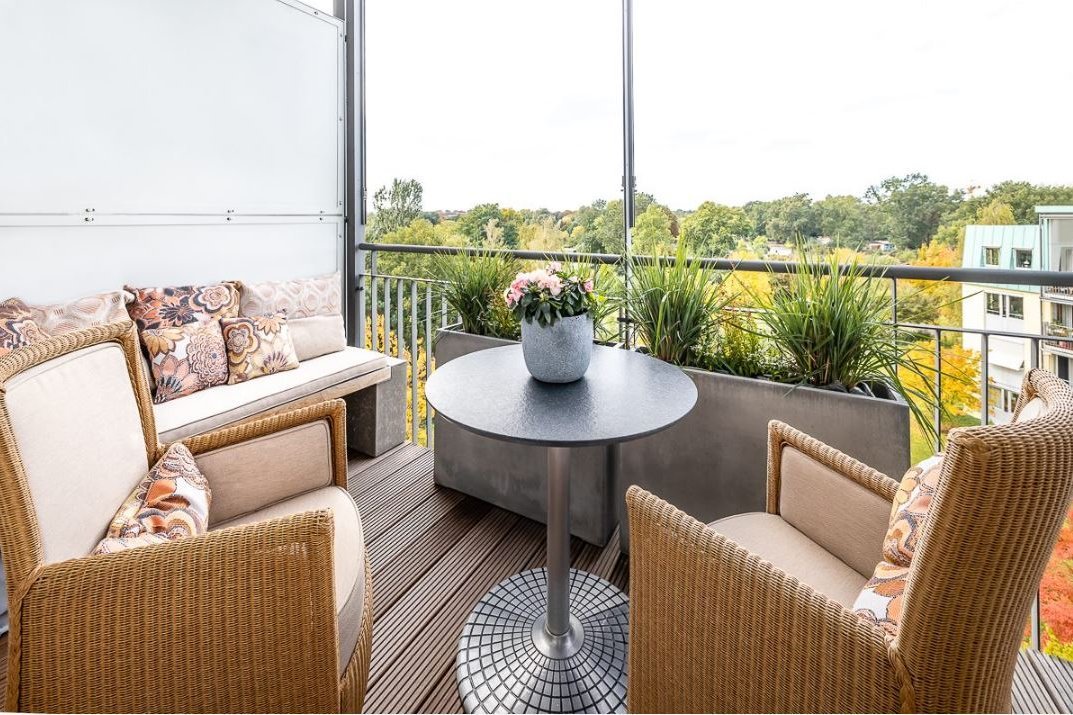 Balkon Gemütliche Sitzmöglichkeiten, ein Tisch und Pflanzen auf einem Balkon