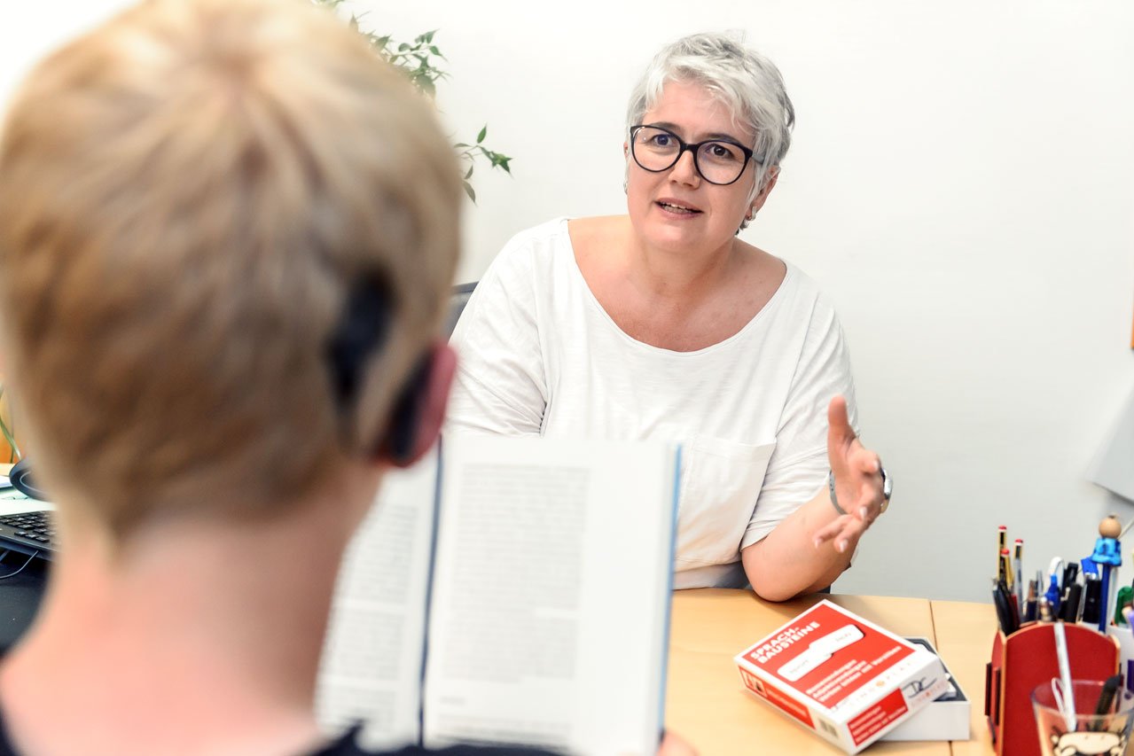 Individuelle Förderung Eine Mitarbeiterin des Fachdienstes fördert einen Schüler in seinem Textverständnis