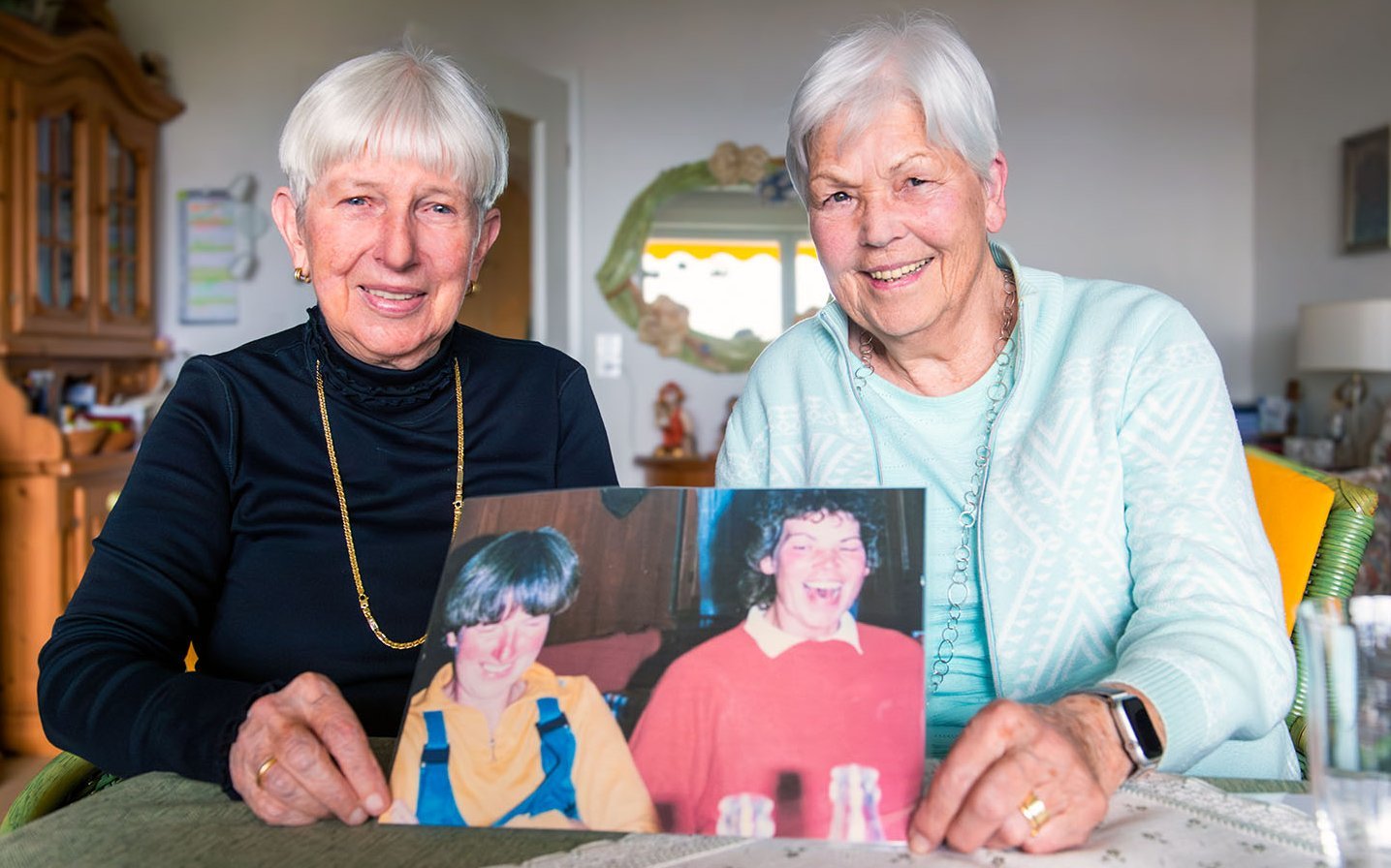 Titelbild Forum: Zwei Frauen halten ein Bild, auf dem sie vor 40 Jahren zu sehen sind