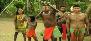 Amazonas-Indianer Kinder und Jugendliche eines Indianervolks aus Amazonien mit traditioneller Kleidung und bemalten Oberkörpern und Gesichtern stehen draußen.
