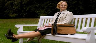 Junge Frau sitzt lächelnd auf Bank Junge Frau sitzt lächelnd auf Bank