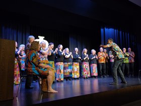Sänger mit afrikanisch inspirieren bunten Röcken beim Neujahrskonzert auf der Bühne des Augustinum Essen
