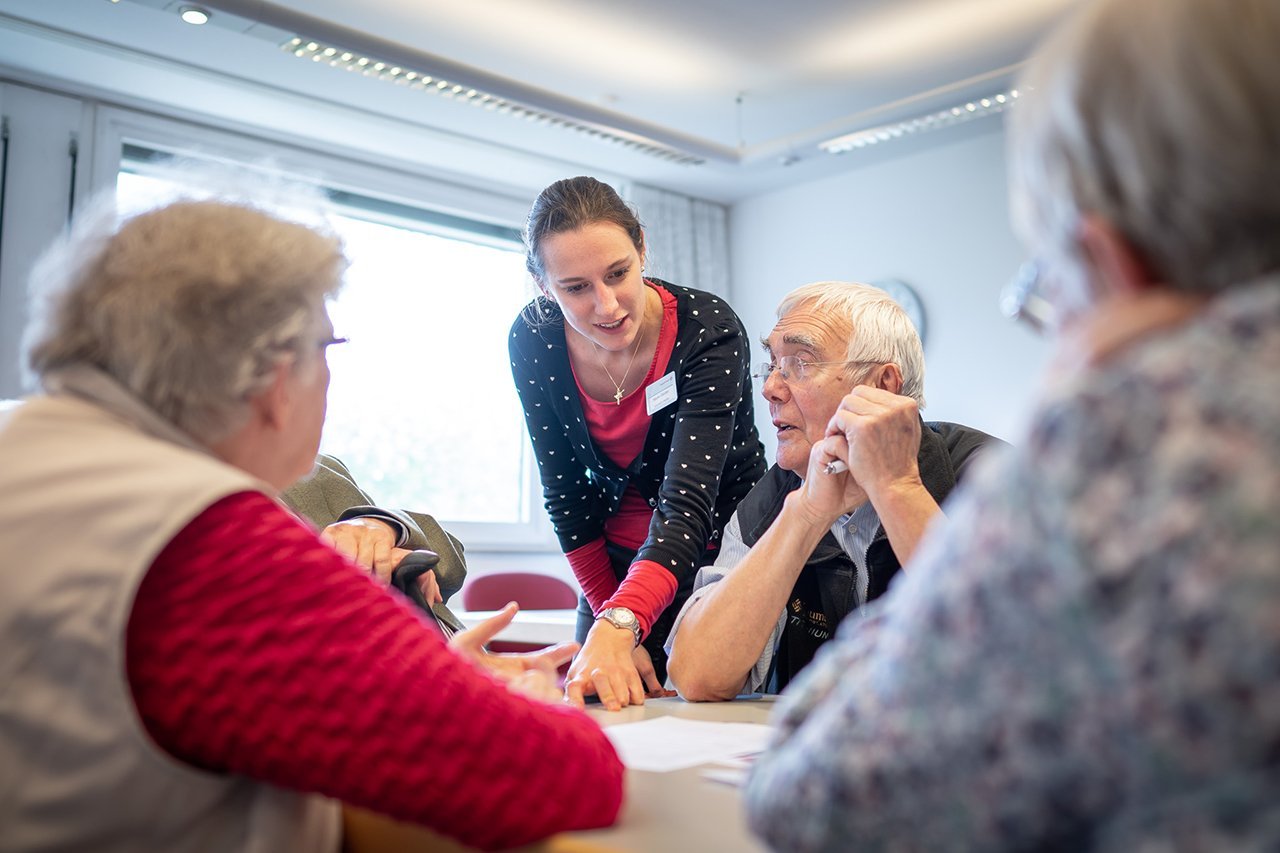 Gedächtnistraining Eine Mitarbeiterin des Augustinum erklärt etwas den Senior*innen