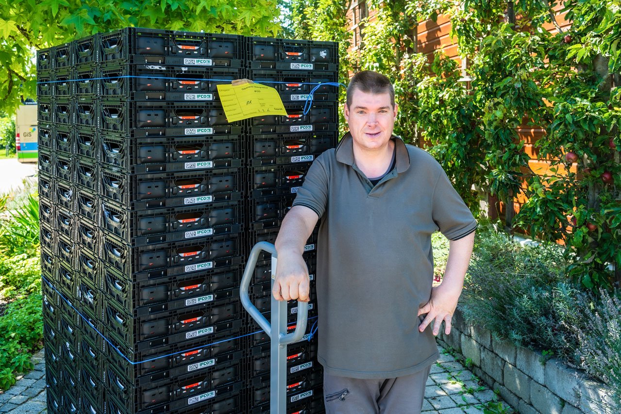 Transport mit Hubwagen Ein Klient der Augustinum Gärtnerei Hollern transportiert Paletten mit einem Hubwagen.