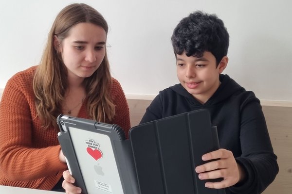 Augustinum Tagesstätte iPads Eine Junge und eine Mitarbeiterin der Augustinum Tagesstätte schauen gemeinsam in ein iPad