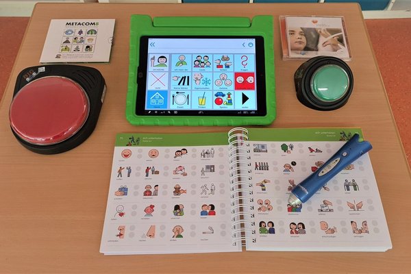 Otto-Steiner-Schule Unterstützte Kommunikation Auf einem Tisch liegen Hilfestellungen zur unterstützten Kommunikation