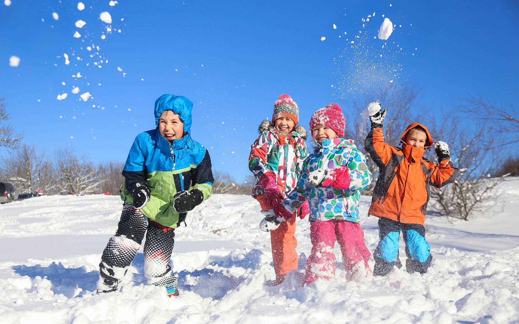 vier Kinder machen eine Schneeballschlacht