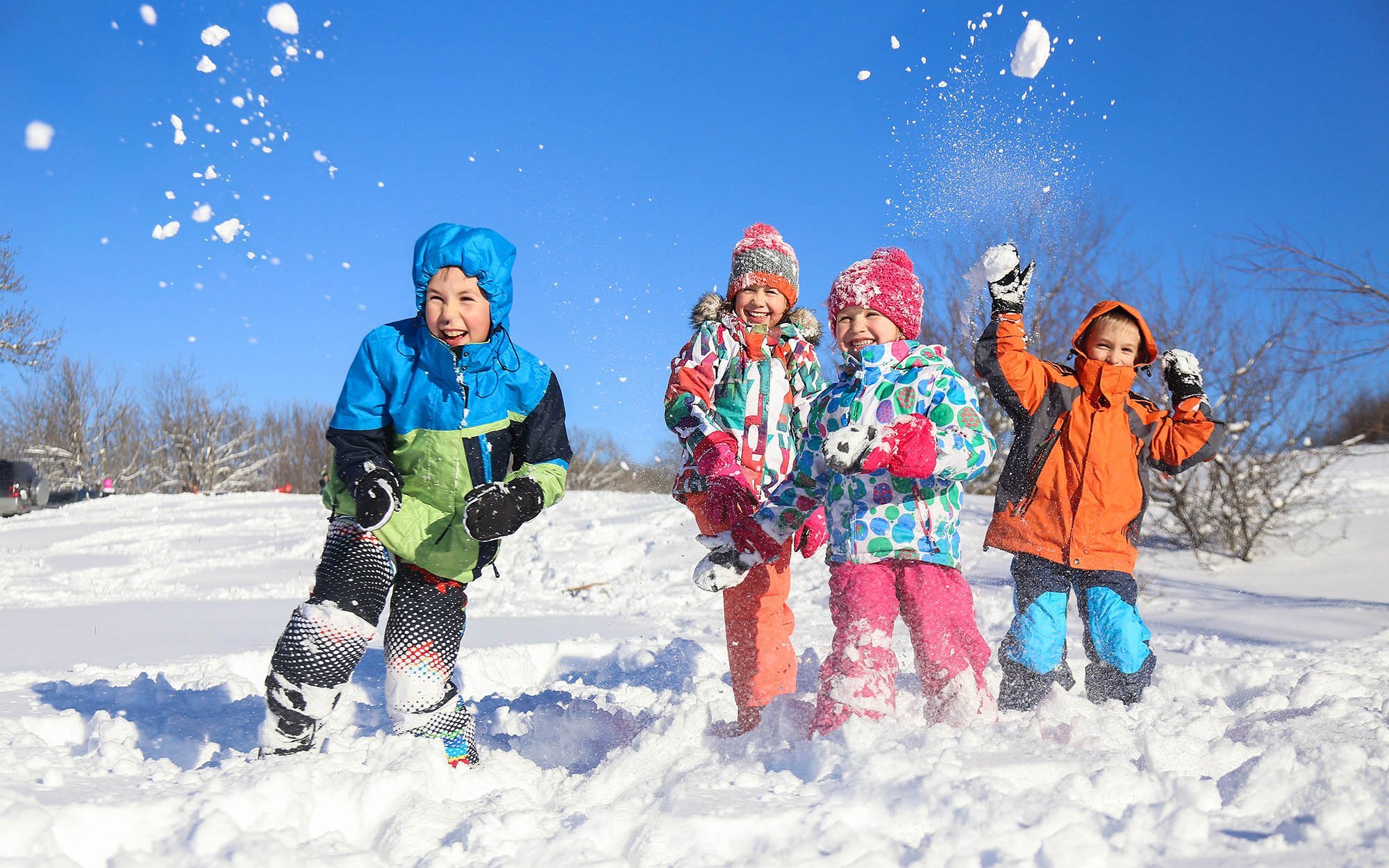 vier Kinder machen eine Schneeballschlacht