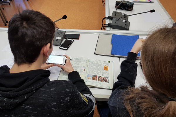 Fachliche Auseinandersetzung Zwei Schüler*innen beschäftigen sich mit den Inhalten eines Chemie-Buchs