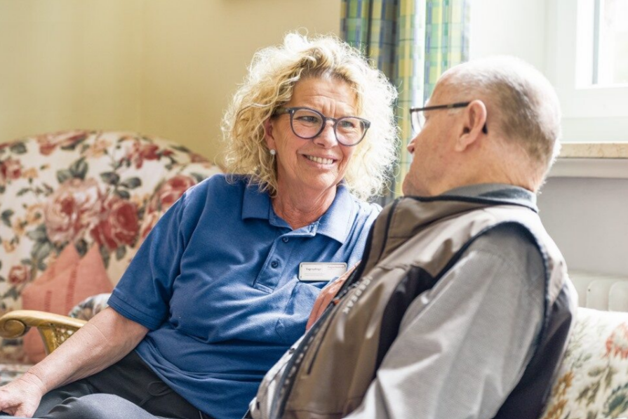 Augustinum Berchtesgadener Land Tagespflege Betreuung Eine Mitarbeiterin der Tagespflege im Austausch mit einem Bewohner