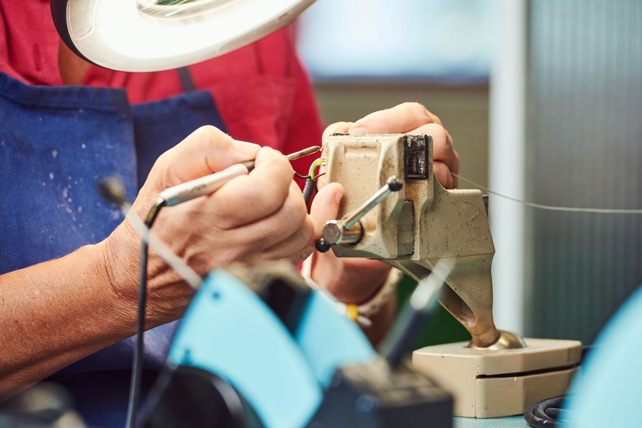 Löten Ein*e Klient*in lötet Kabel im Bereich Kabelkonfektionierung