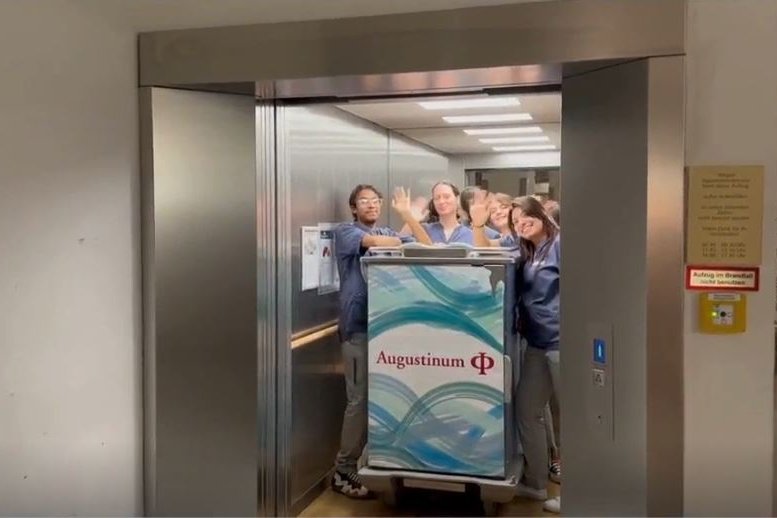Augustinischer Geist Mitarbeiter*innen des Augustinum stehen in einem Fahrstuhl und winken