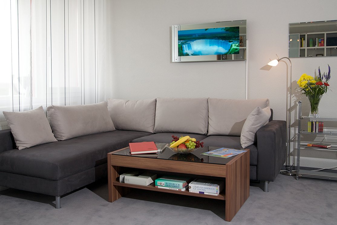 Die Wohnungen im Augustinum Bad Soden können ganz individuell nach eigenem Geschmack eingerichtet werden. Modernes Ecksofa und Tisch