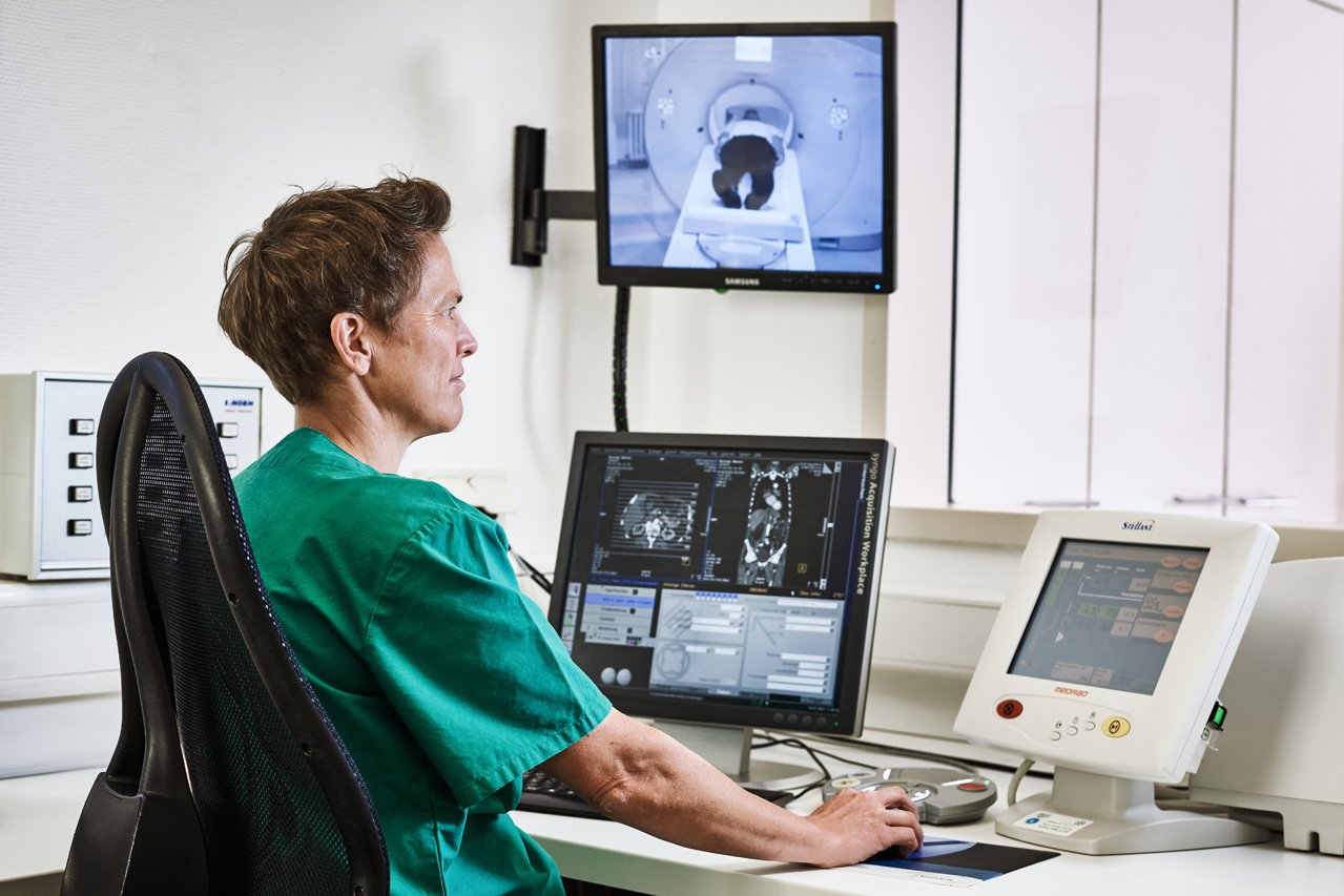 Computertomographie Eine Mitarbeiterin der Augustinum Klinik kontrolliert vor mehreren Bildschirmen sitzend eine Computertomographie