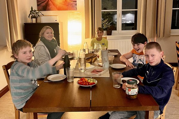 Augustinum Landschulheim Elkofen Wohnen Eine Mitarbeiterin des Augustinum Landschulheims sitzt mit vier Jungs an einem Esstisch