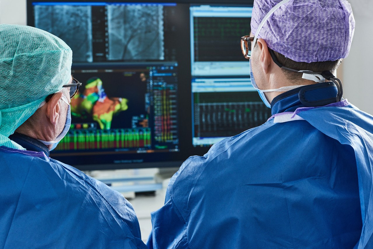 Analyse der Mappingbilder Zwei Ärzte begutachten nach einem Eingriff an einem Monitor die Mappingbilder