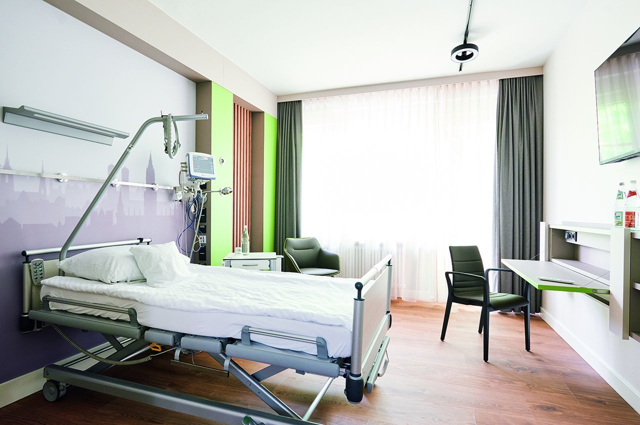 Augustinum Klinik Wahlleistungsstation Ein-Bett-Zimmer Ein Ein-Bett-Zimmer der Augustinum Klinik Wahlleistungsstation mit einem Fernseher und einem Tisch