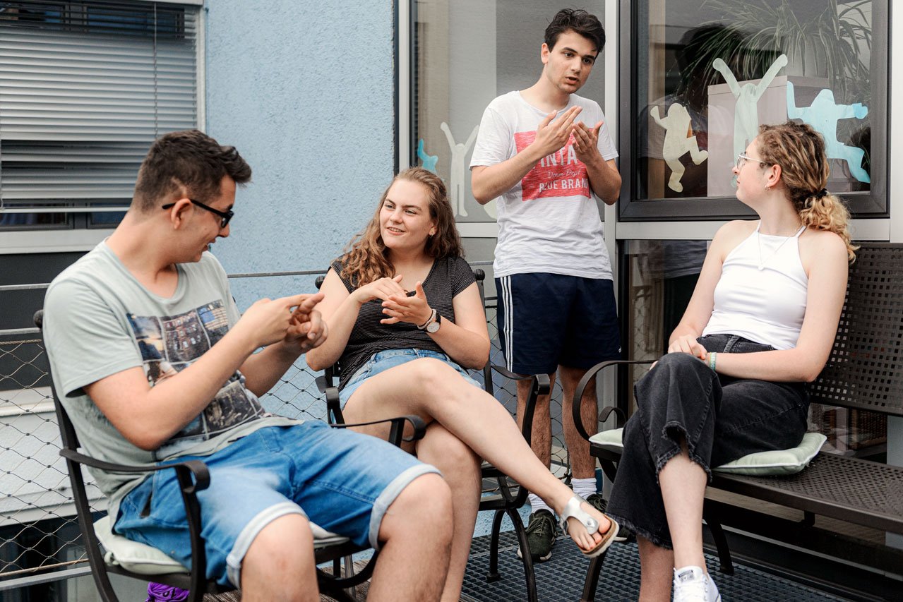 Zeit für Freunde Eine Gruppe von Freunden unterhält sich in Gebärdensprache auf der Terrasse des Augustinum Studienheims
