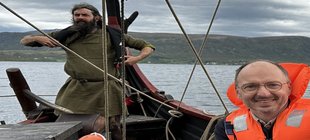 Mann in Schwimmweste auf Wikingerboot Mann in Schwimmweste auf Wikingerboot