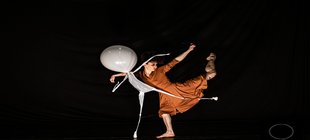 Eine Frau tanzt mit einem weißen Figur