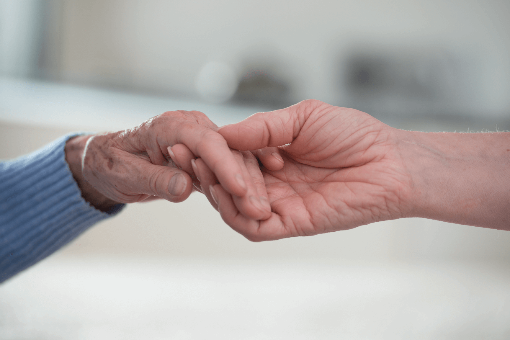 Wertschätzende individuelle Betreuung und Versorgung Junge Hand, die alte Hand hält