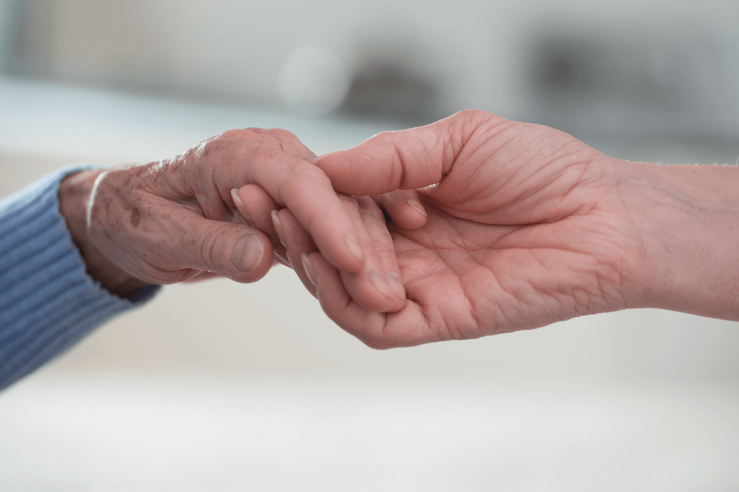 Wertschätzende individuelle Betreuung und Versorgung Junge Hand, die alte Hand hält