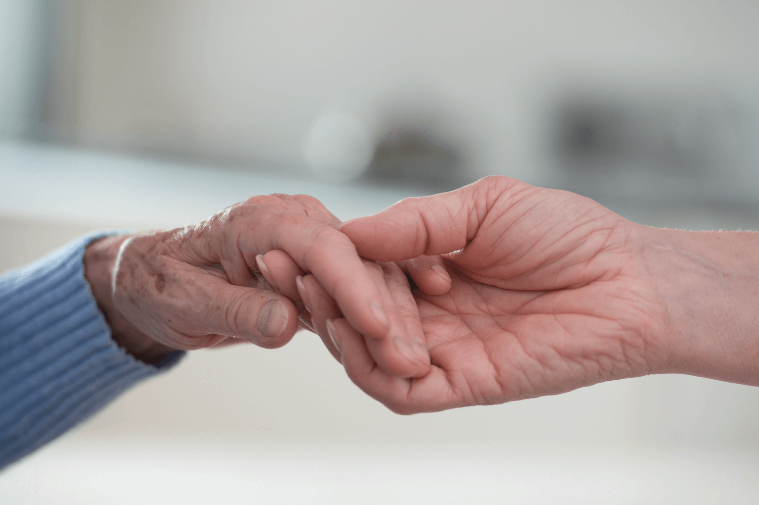 Wertschätzende individuelle Betreuung und Versorgung Junge Hand, die alte Hand hält