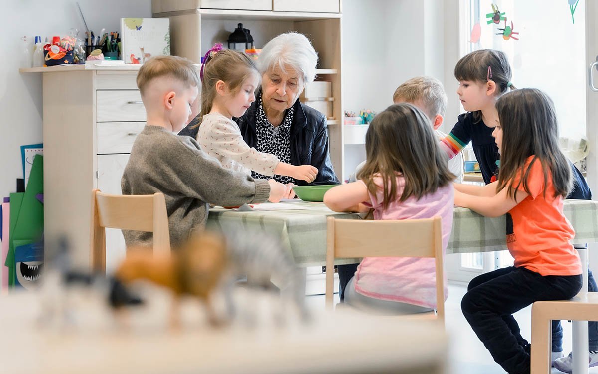 Lissy Benkler umringt von Kindergartenkindern an einem Tisch