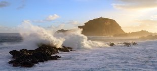Aufgewühltes Wasser trifft auf einen Felsen