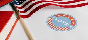 Vortrag mit Dr. Uwe Christiansen USA Flagge und Aufkleber "Vote"