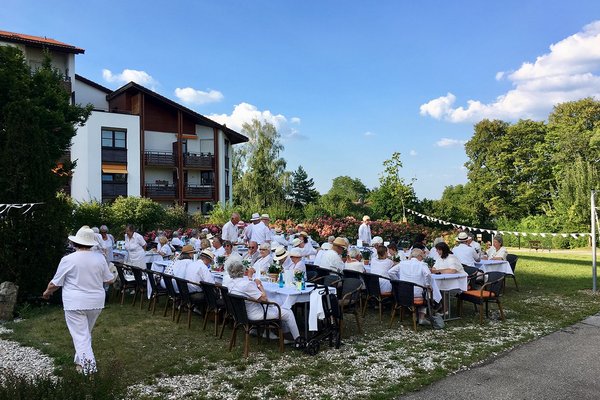 Augustinum Seniorenresidenz Dießen Feste Senior*innen in weißen Klamotten sitzen an großen Tischen
