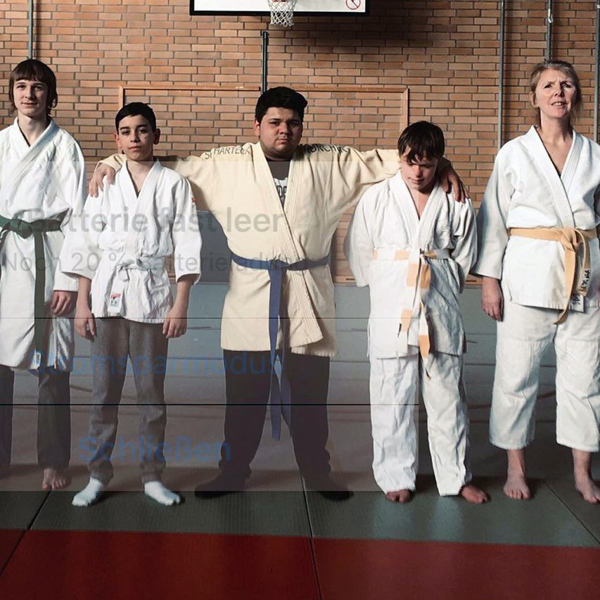 Das ID-Judo-Choreografie-Team des Augustinum Behinderte Judoka stehen Arm in Arm nebeneinander