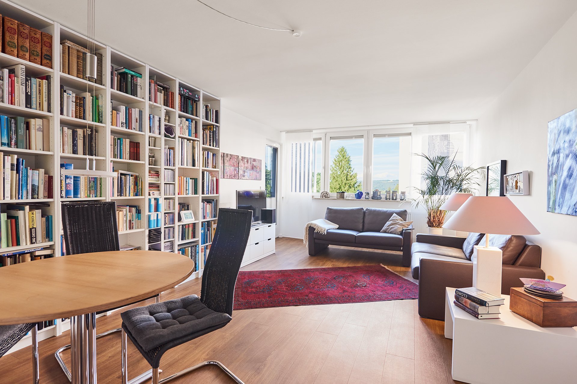 Augustinum Seniorenresidenz Dießen Wohnung Slider Eine Wohnung mit Sitzmöglichkeiten und einem großen Bücherregal