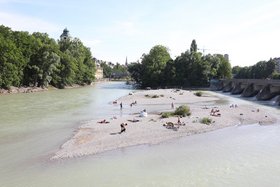 Die Isar in München mit Badegästen am Ufer Fluss