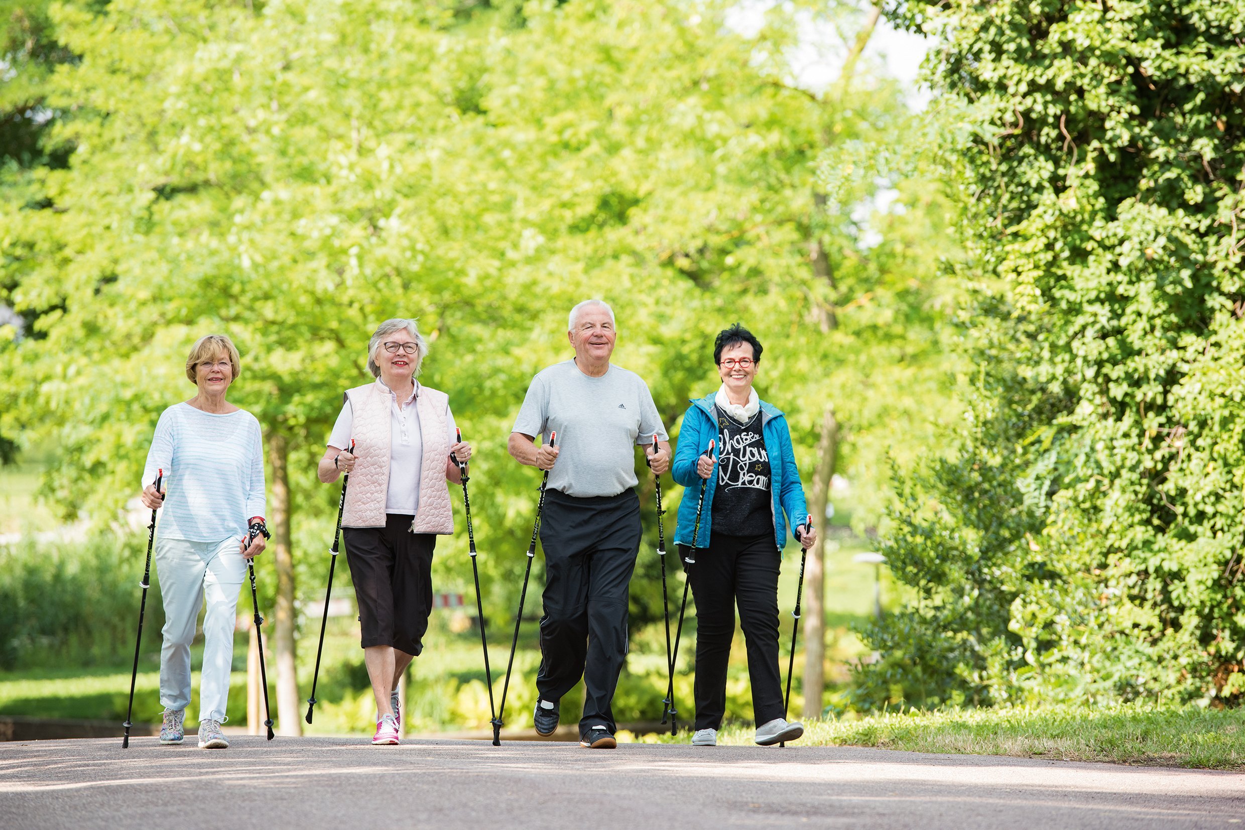 Augustinum Seniorenresidenzen Wandergruppe Vier Senior*innen wandern mit Wanderstöcken