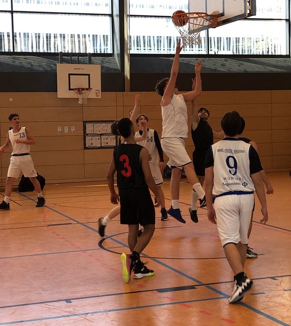 Augustinum Basketball Deutsche Meister Schüler der Samuel-Heinicke-Realschule spielen in einer Sporthalle Basketball. Einer der Schüler wirft einen Korb.