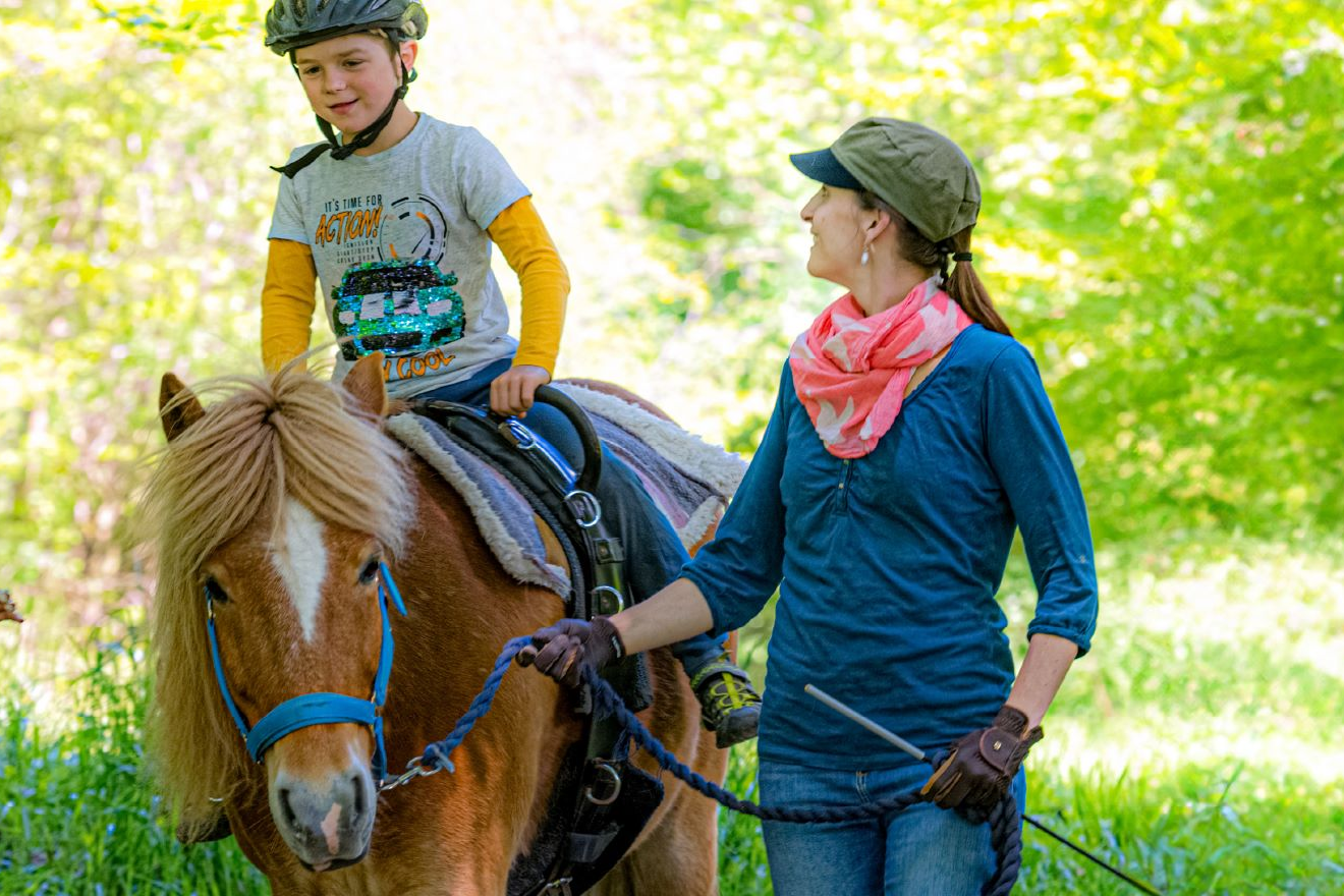 Reittherapie-Patenschaft Ein Junge bei der Reittherapie