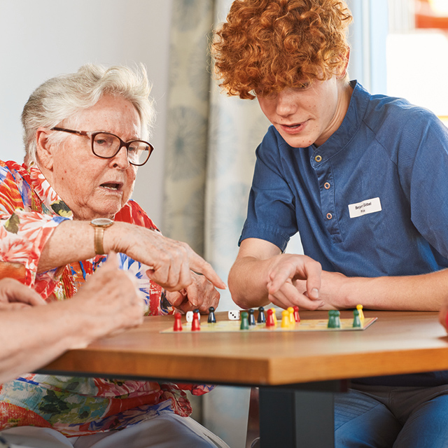 Augustinum Freiwilligendienste Einsatzstelle Sanatorien Ein Freiwilliger des Augustinum spielt ein Brettspiel mit einer Bewohnerin